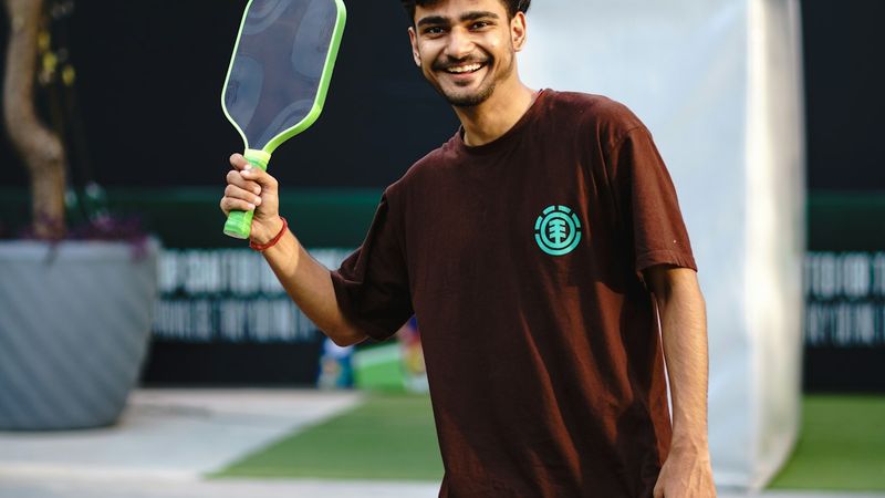 Player holding a pickleball paddle on an outdoor court