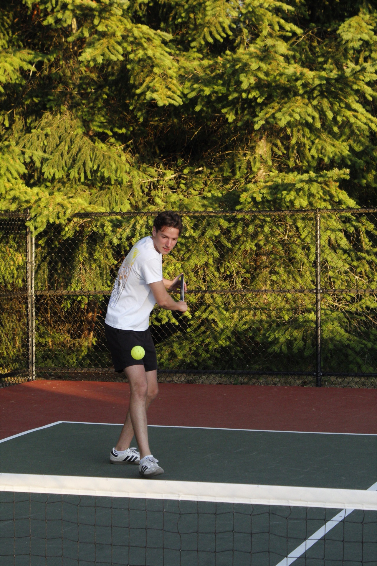 A pickleball player preparing to hit on an outdoor court