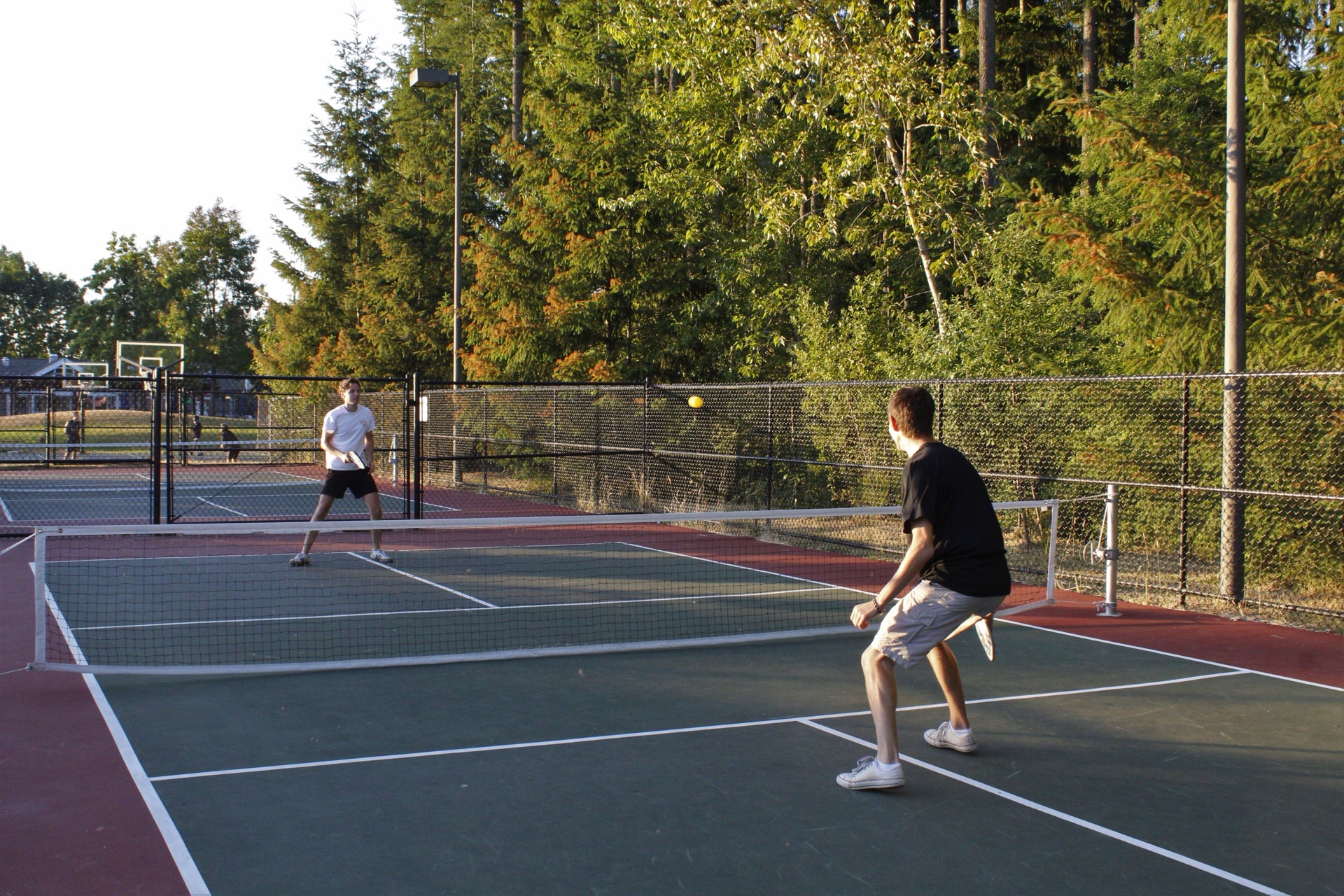 Two players in a rally on an outdoor pickleball court